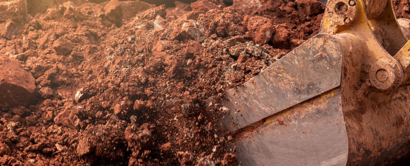 closeup bucket of backhoe digging soil at construction site valdosta ga